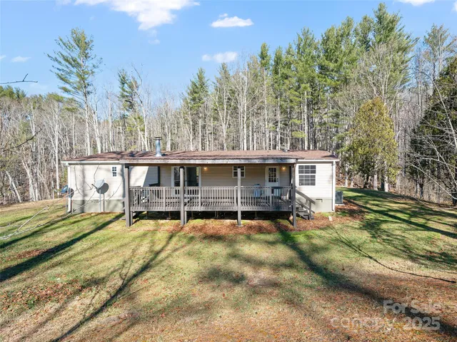 a view of a house with a wooden deck and a big yard