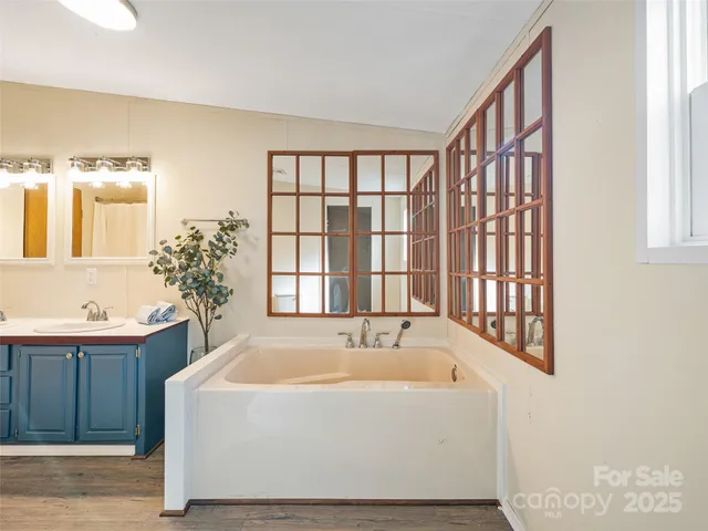 a white bath tub sitting in a bathroom next to a window