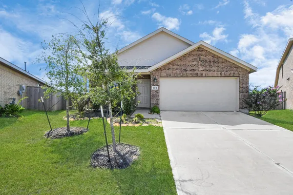a front view of a house with a yard and a garage