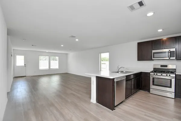 a kitchen with stainless steel appliances granite countertop a stove top oven and sink