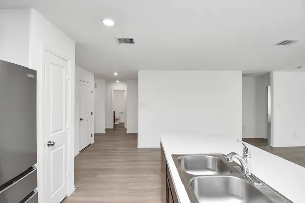 a view of a kitchen with a sink and refrigerator