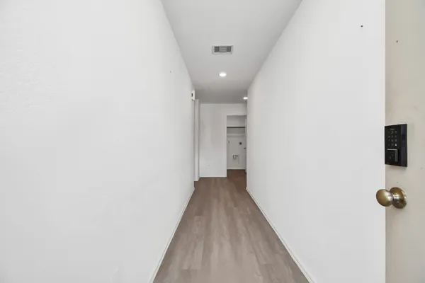 a large white kitchen with wooden floor