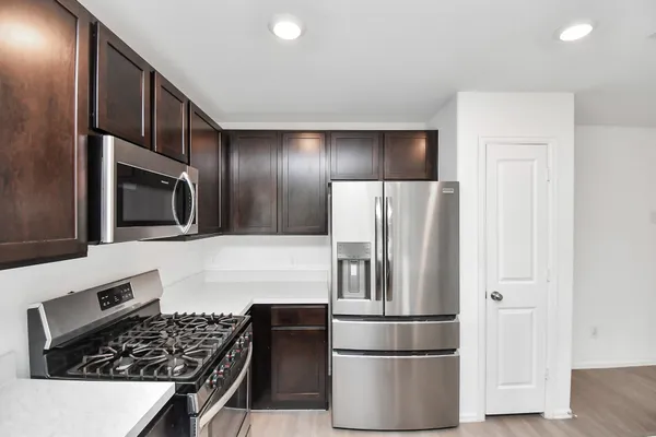 a kitchen with stainless steel appliances granite countertop a refrigerator and a stove top oven