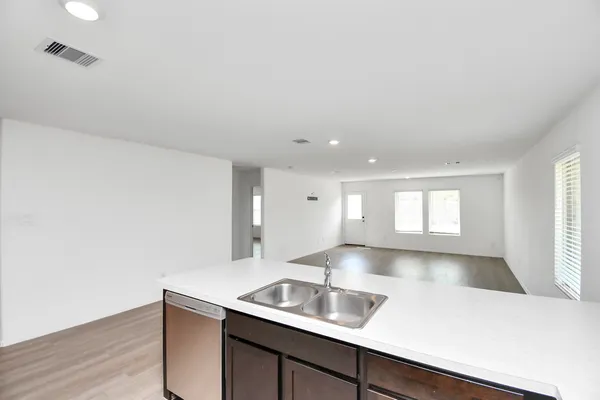 a kitchen with a sink cabinets and wooden floor