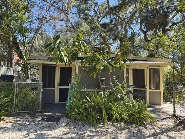 a front view of a house with a tree