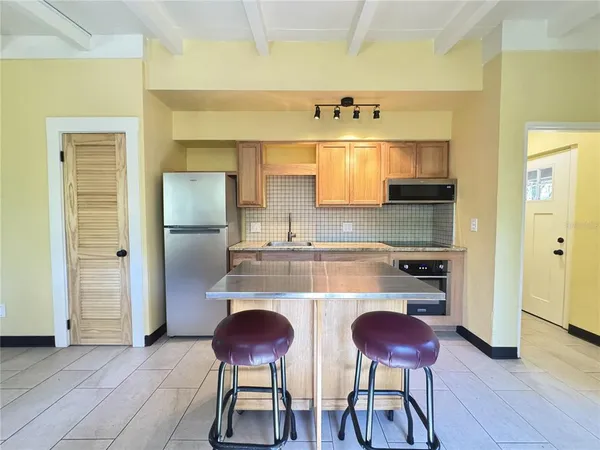 a view of a kitchen cabinets and a refrigerator