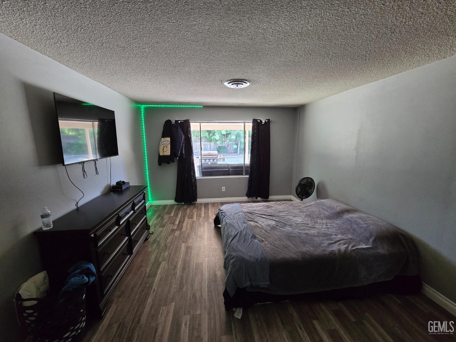 Undisclosed Address Bakersfield, CA 93309 - Photo 8 of 14 a bedroom with a bed and a flat tv screen on dresser