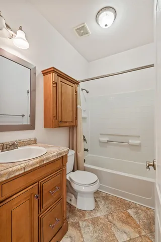 a bathroom with a granite countertop sink a toilet and shower