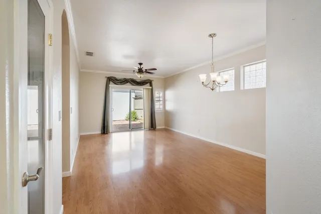 a view of a room with wooden floor and chandelier