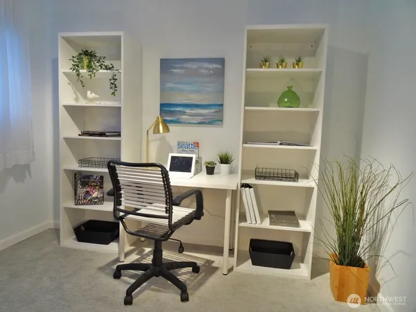 a view of a workspace with furniture and a window