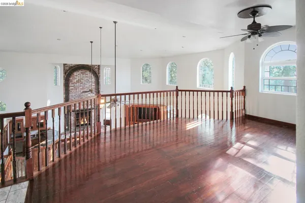 a view of hallway with wooden floor and a large window