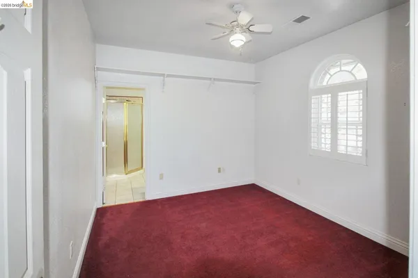 an empty room with windows and closet area