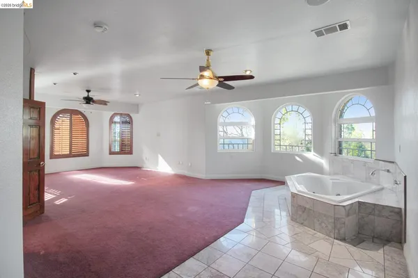 a view of a livingroom with a ceiling fan window and a chandelier
