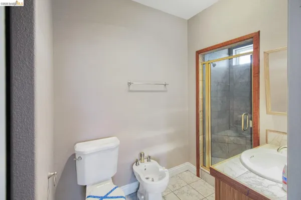 a bathroom with a granite countertop sink mirror vanity and toilet