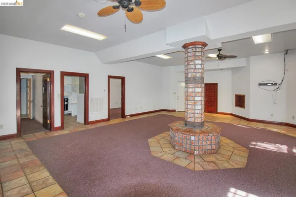a open kitchen with stainless steel appliances a large counter top a stove a chimney a sink and a large window