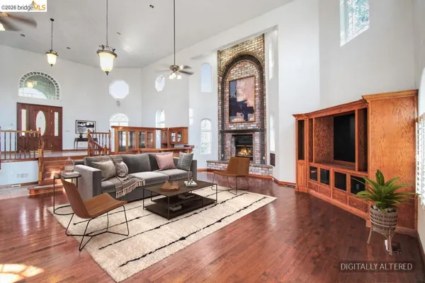 a living room with furniture a flat screen tv and a floor to ceiling window