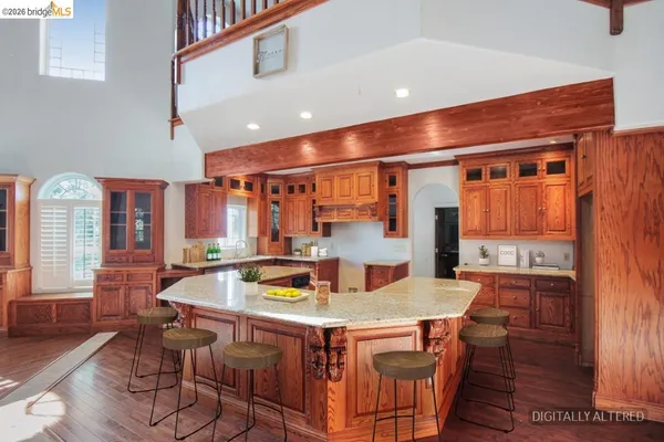 a kitchen with a stove a refrigerator and a dining table with wooden floor