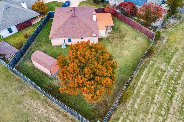 an aerial view of residential houses with outdoor space and street view