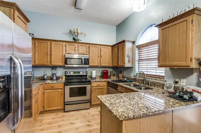 a kitchen with stainless steel appliances granite countertop a stove sink microwave and cabinets