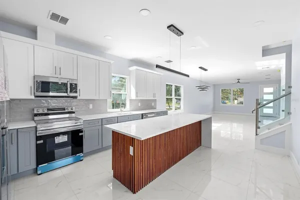 a kitchen with stainless steel appliances a sink stove and cabinets