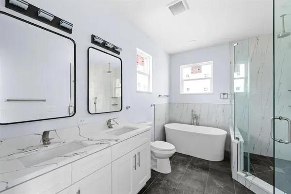 a spacious bathroom with a double vanity sink mirror and toilet