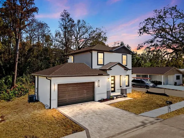 a front view of a house with yard and trees