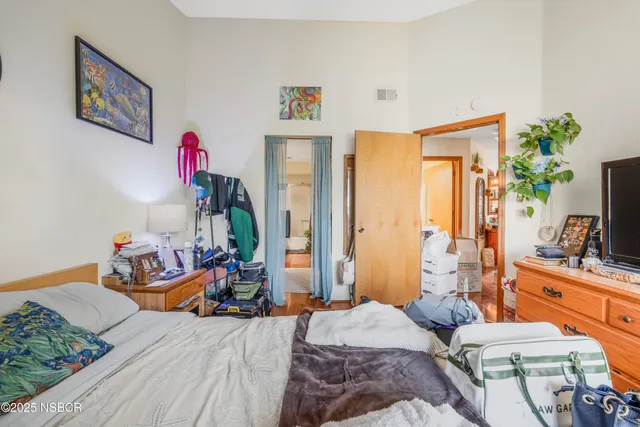 a bedroom with bed and a flat tv screen