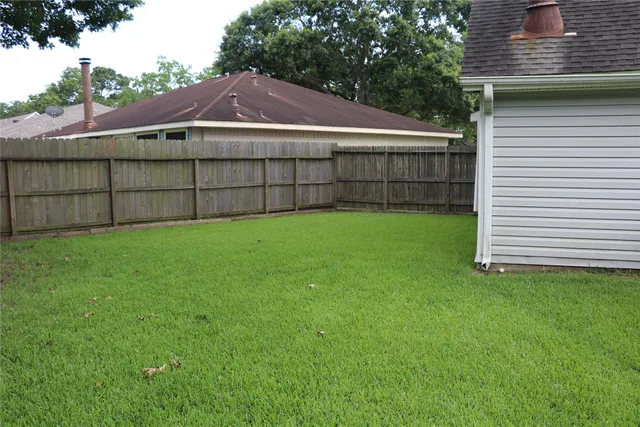 a view of a house with a yard and wooden fence
