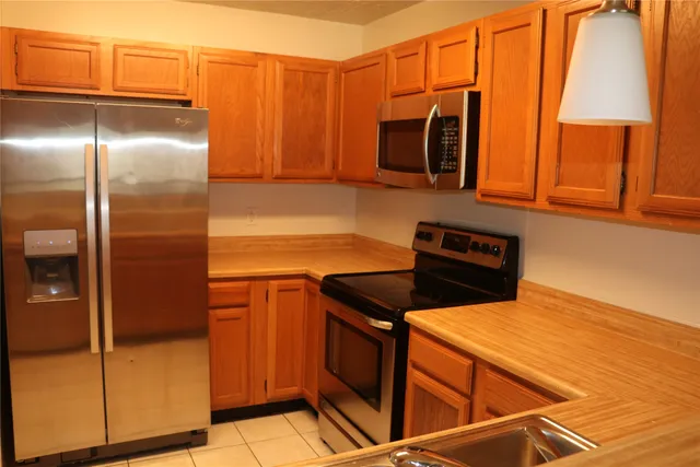 a kitchen with stainless steel appliances a refrigerator stove and microwave
