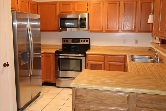 a kitchen with stainless steel appliances granite countertop a refrigerator stove and sink