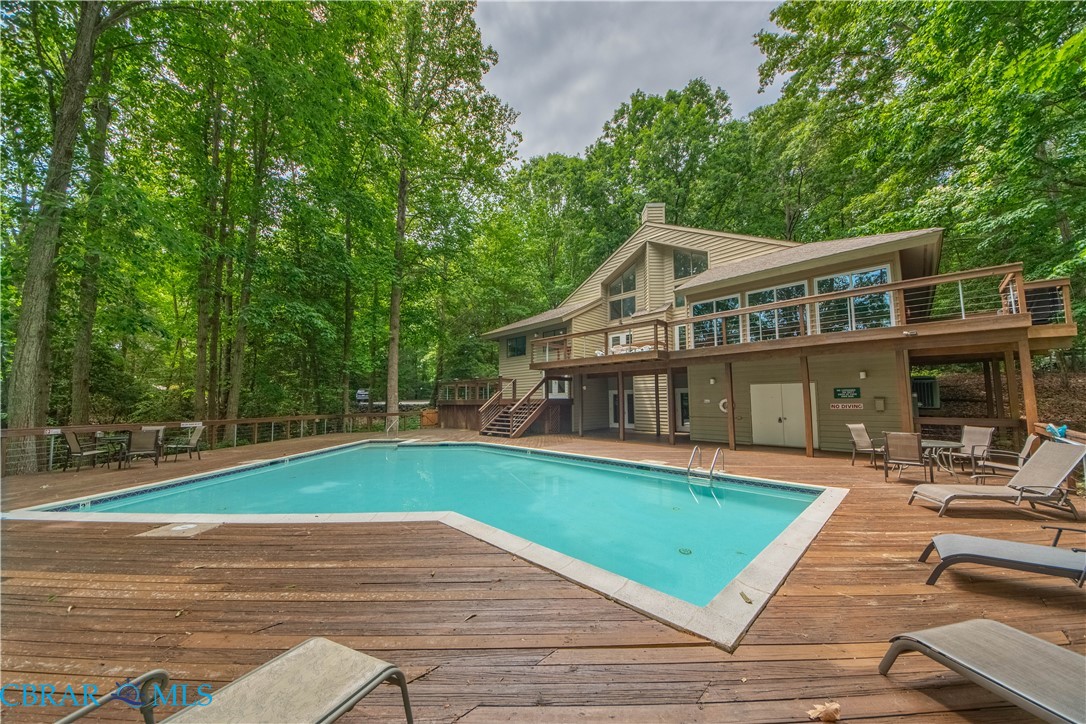 54 Villa Ridge Drive, Unit C Hartfield, VA 23071 - Photo 28 of 45 Community pool featuring a wooden deck, outdoor dining area, and a patio