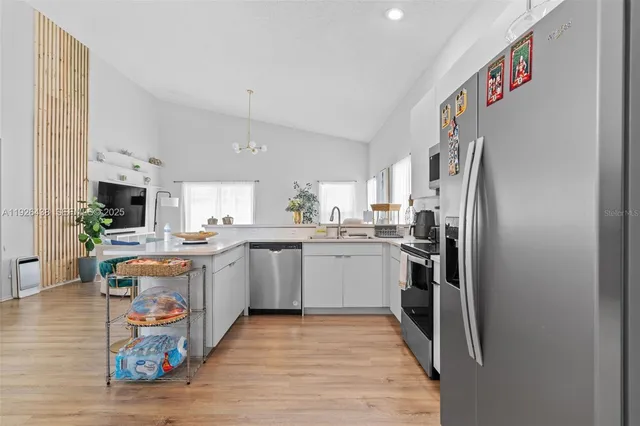 a kitchen with stainless steel appliances granite countertop a refrigerator and a sink