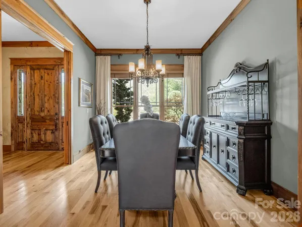 a dining room with furniture large windows wooden floor and garden view