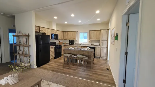 a kitchen with refrigerator a microwave and chairs