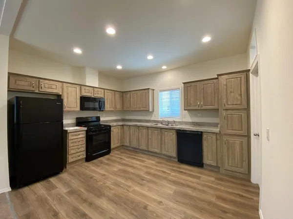 a large kitchen with a large counter top stainless steel appliances and cabinets