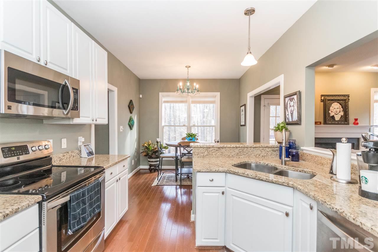 6020 Wild Orchid Trail Raleigh, NC 27613 - Photo 5 of 26 Open, updated kitchen with white cabinets, granite countertops and S/S appliances