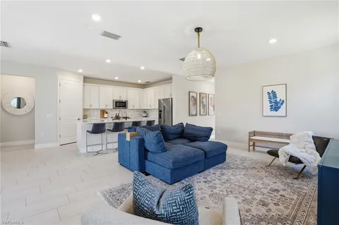 a living room with furniture kitchen and a chandelier