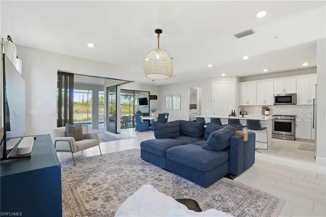 a living room with furniture kitchen view and a large window