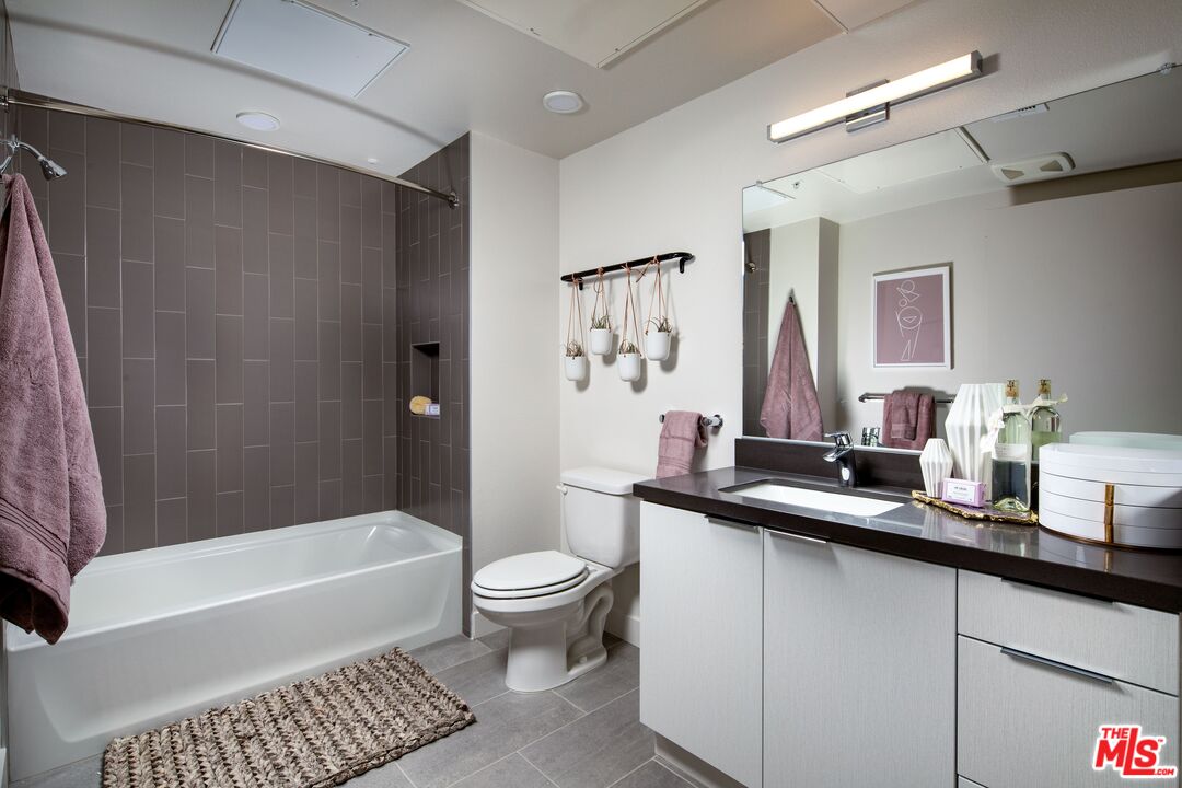 1101 North Main Street, Unit B326 Los Angeles, CA 90012 - Photo 7 of 35 a bathroom with a sink a toilet a mirror a bathtub and shower