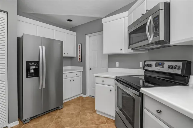 a kitchen with stainless steel appliances granite countertop a refrigerator stove and microwave