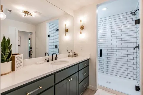 a bathroom with a sink a shower and a mirror