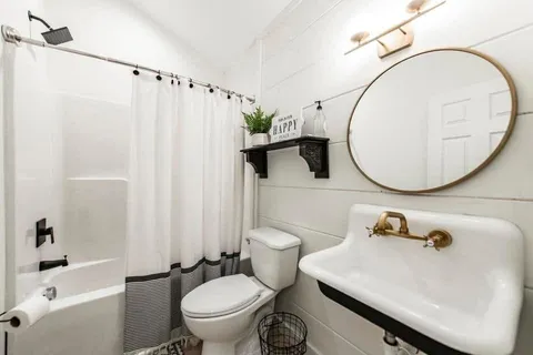 a bathroom with a sink toilet and a mirror