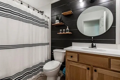 a bathroom with a sink toilet and mirror