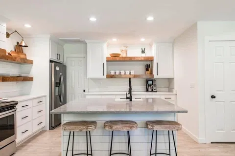 a kitchen with kitchen island granite countertop a sink and cabinets