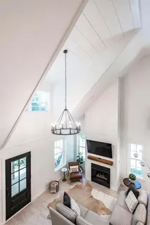 a living room with furniture a chandelier and a flat screen tv