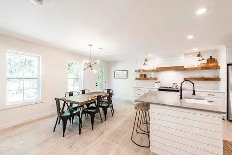 a kitchen with a table chairs and white cabinets