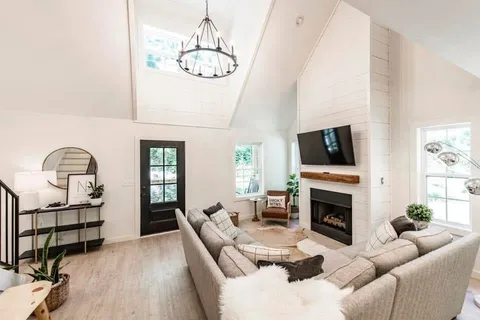 a living room with furniture a flat screen tv and a fireplace