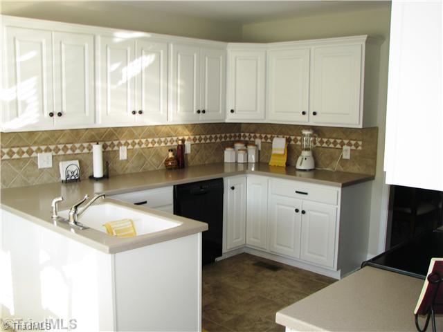 286 Crousetown Road Lexington, NC 27292 - Photo 6 of 16 Kitchen. This home offers a wonderfully effecient kitchen with tiled floors, tiled back splash, a free standing range/oven, a refigerator and a built-in microwave.