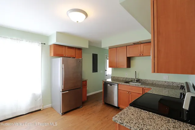 a kitchen with stainless steel appliances granite countertop a refrigerator a sink a stove and island