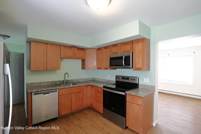 a kitchen with stainless steel appliances granite countertop a stove a sink and a refrigerator